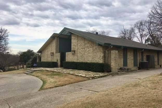 On one side is the living room, which also boasts a vaulted ceiling, as  well as an expansive brick fireplace, a large hexagonal picture window  facing the