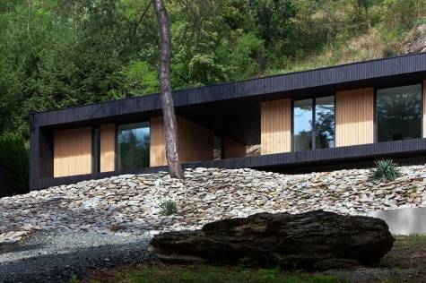 The strongest feature of this modern cottage is the cantilevered roof  sheltering the area between the living space and the outdoor terrace