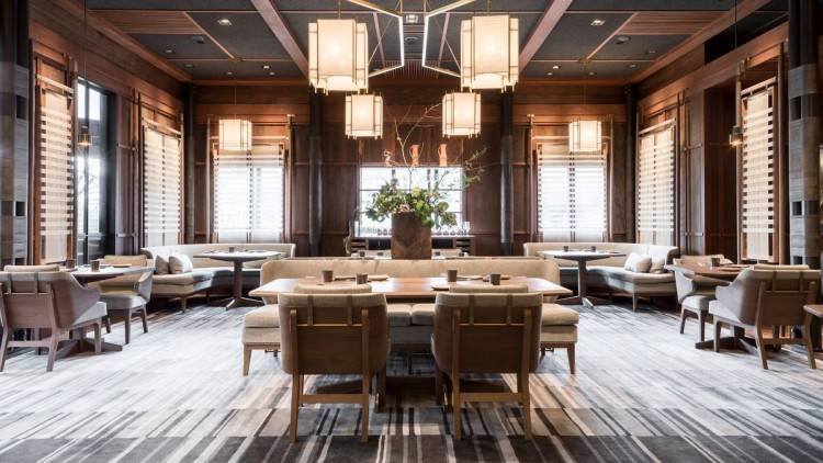 Italian architect Achille Salvagni's Octopus chandelier stretches above the  sculptural table by Joseph Walsh Studio in the dining room of Clarissa and  Edgar