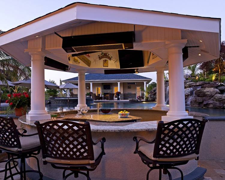 The pool bar and outdoor dining flank one end of  the pool