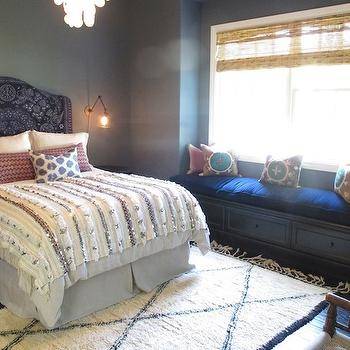 Bright, white bedroom with pretty Moroccan rug, indigo throw over white  linens, lots of pretty textiles